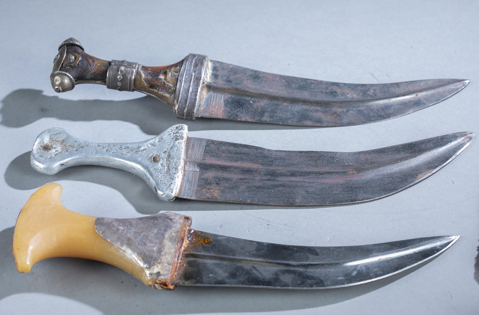 3 Yemeni Jambiya daggers: A group of three Yemeni Jambiya or Djambia daggers. One 19th Century dagger has horn handle with silver mounts. Largest 12" and smallest 12 1/2" Provenance: From an estate in Baltimore, MD.