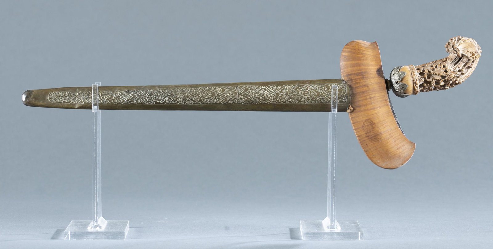 Indonesian kris dagger.: Indonesia Pasikutan kris or keris dagger, Late 19th century. Eight Luk double edged 14 1/2" blade with pamor. Carved bone ukiran handle with foliate motifs. Silver selut. Wood warangka with embossed b