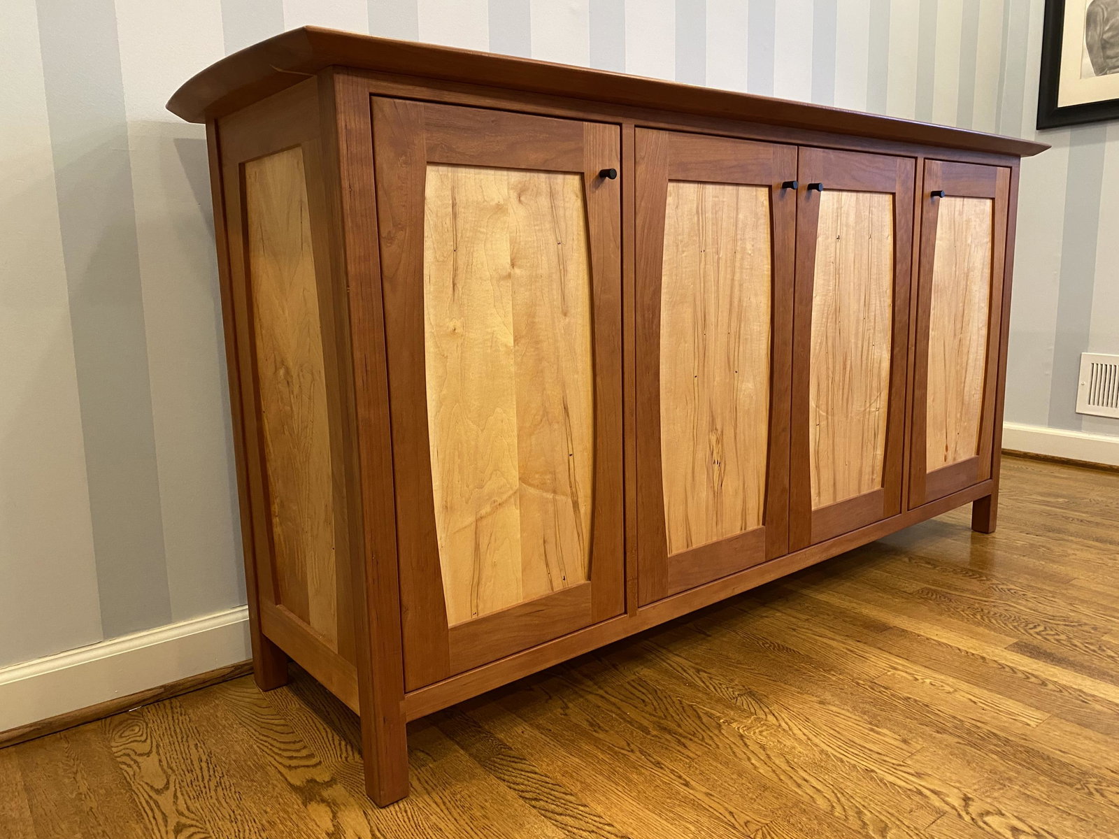 Hardwood Artisans sideboard.: A Hardwood Artisans custom made cherry and maple sideboard with four paneled doors. c.2016. Custom made for the Hebert family.Copy of drawings included. 37" x 74" x 15" Provenance: From the collection