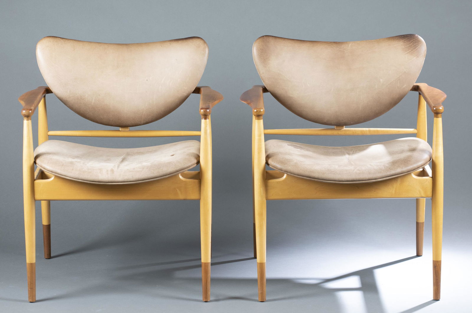 2 Finn Juhl Niels Vodder Model 48 armchairs.: A set of two Model 48 armchairs designed by Finn Juhl and Niels Vodder. Brown leather with a two-tone maple and walnut wood frame. 31 1/2" x 27 5/8" x 23". Condition: Wear, stain to seat cushion, and