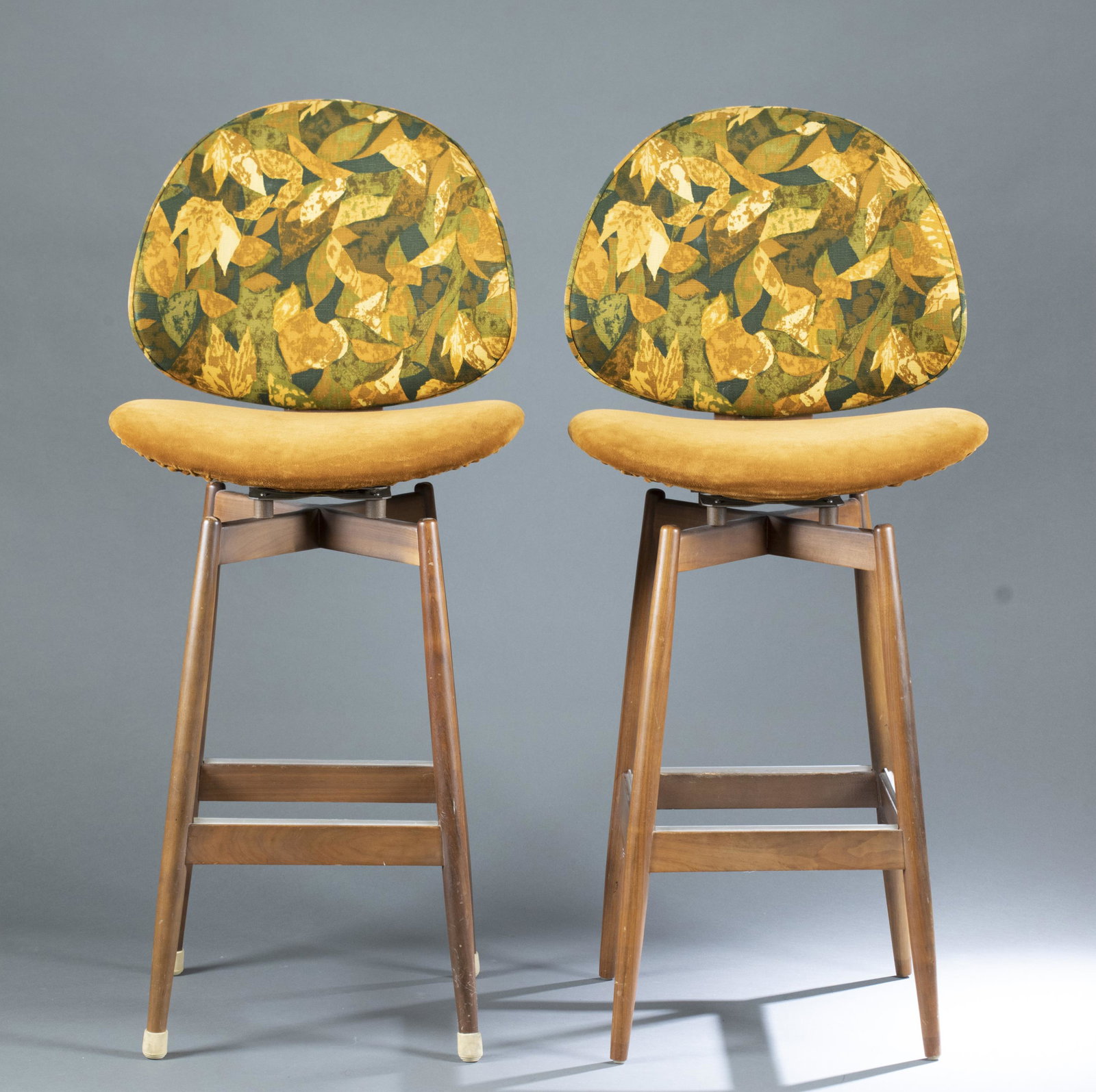 2 Kodawood bar stools.: A pair of two American modern Kodawood swivel bar stools with brown and patterned upholstery and teakwood base. Marked on bottom. Miami, Florida. Circa mid-20th century. 45 1/8" x 20". Provenance: Fro