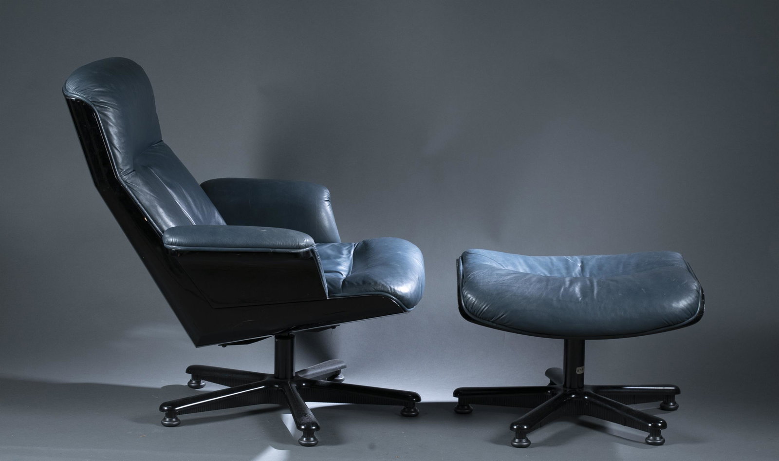 Italian leather recliner and ottoman.: An Italian modern teal leather recliner and matching ottoman with black frames. Marked on bottom "Made in Italy." Recliner: 35 1/2" x 32" x 33". Ottoman: 16" x 24" x 21". Condition: Scuffs on leather,
