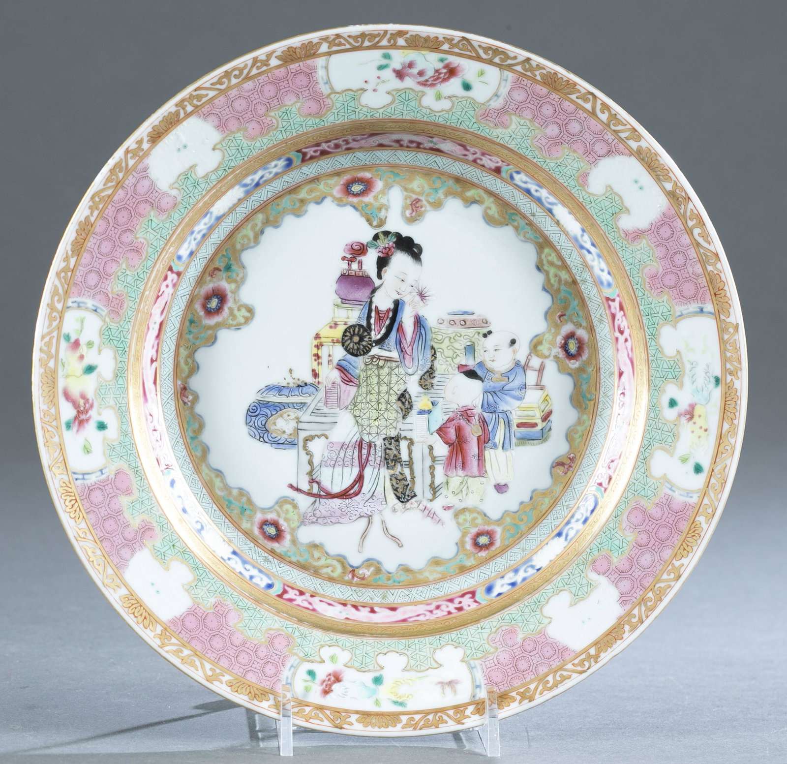 Chinese export famille rose porcelain plate.: A Chinese export famille rose porcelain plate. Depicting a lady amusing two children. Decorated with pink and gilt floral and traditional Chinese symbols. Unmarked. 1" x 9". Condition: Some glaze pops