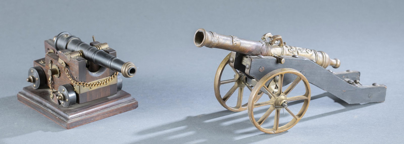 2 miniature cannons.: A group of two miniature cannons. ++ Brass canon with Spanish coat of arms and 1651 date on carriage. 10" cannon. Carriage 4" x 10" x 4 1/2" ++ Decorative desk cannon on stand. 4 1/4" x 8 1/2" x 4 3/4
