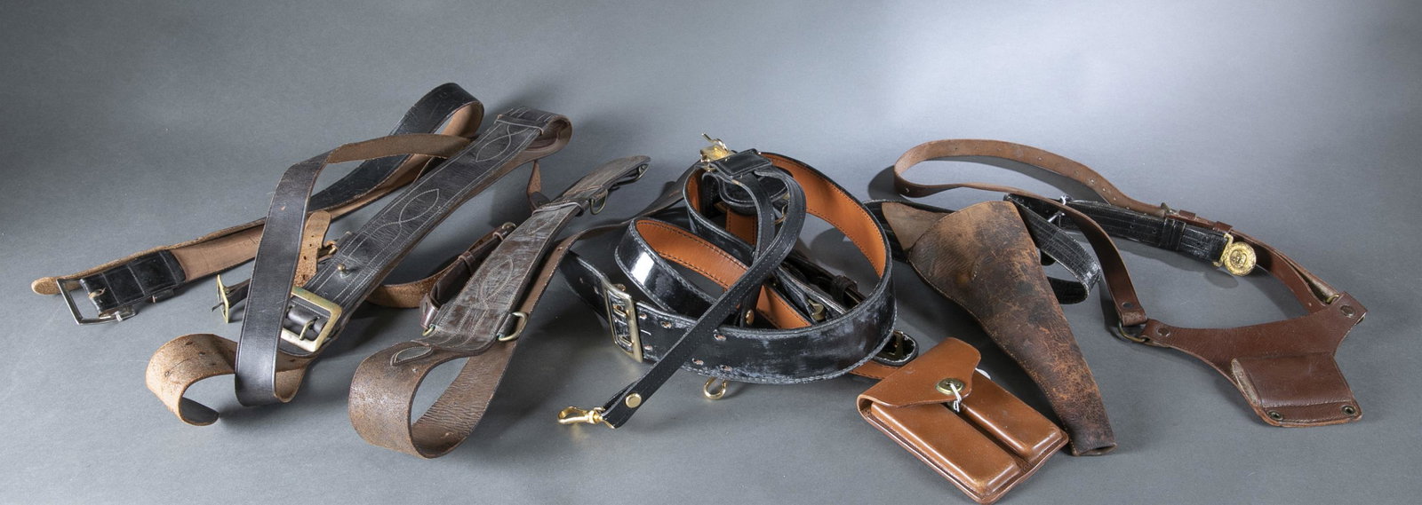 Group of leather military belts: A group of vintage leather military belts including U.S. Army, U.S. Marine Corps, and U.S. Navy. Also includes 19th century pistol holder, leather ammo pouch.