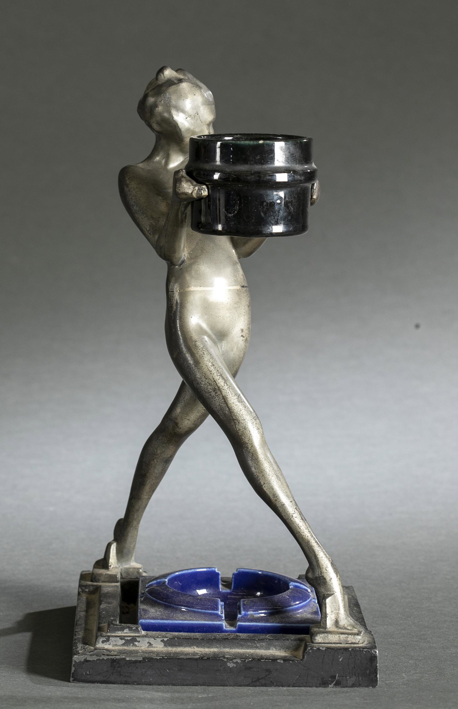 Frankart Art Deco ash tray.: A Frankart Art Deco cast iron ash tray. Nude woman holding a basket. Includes original held ceramic cigarette holder and replacement ceramic ash tray. 13" x 6 1/2"Condition: Chipping paint.Provenance: