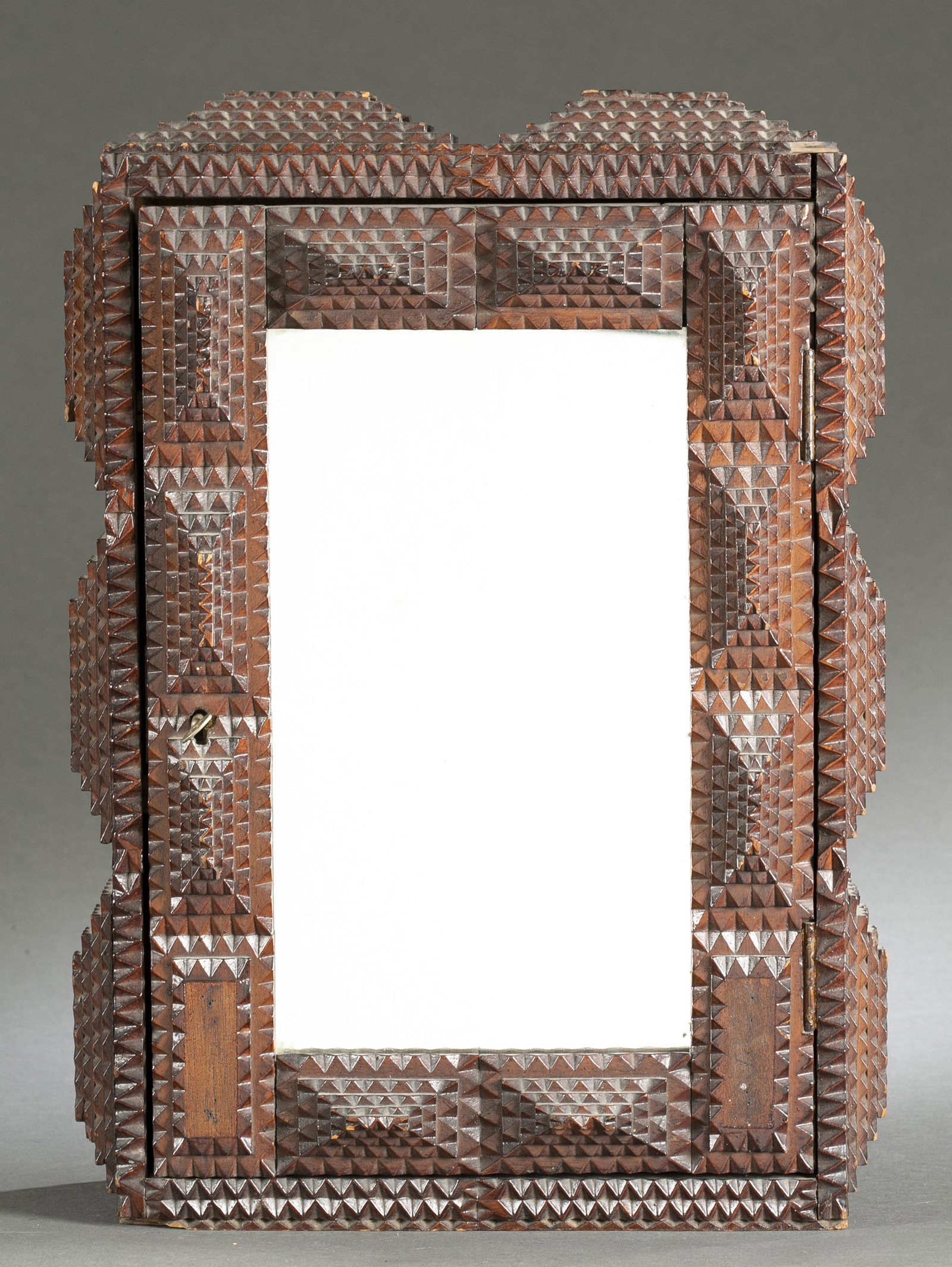 Tramp Art mirrored cabinet.: A Tramp Art mirrored cabinet. Mirror on front of cabinet, key included. Three interior shelves. Late 19th century/early 20th century. 21" x 15" x 5".