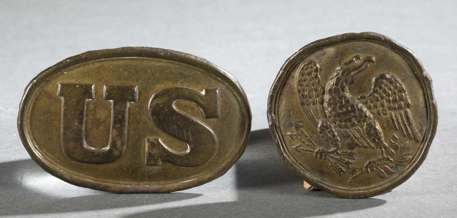 2 Union Civil War plates.: A group of two Union Civil War plates. ++ Union eagle waist belt plate, Circa 1839-1874. Stamped brass lead filled. Three hook design. Marked on back "HAL." 2.5" across ++ U.S. oval NCO and Bayonet be