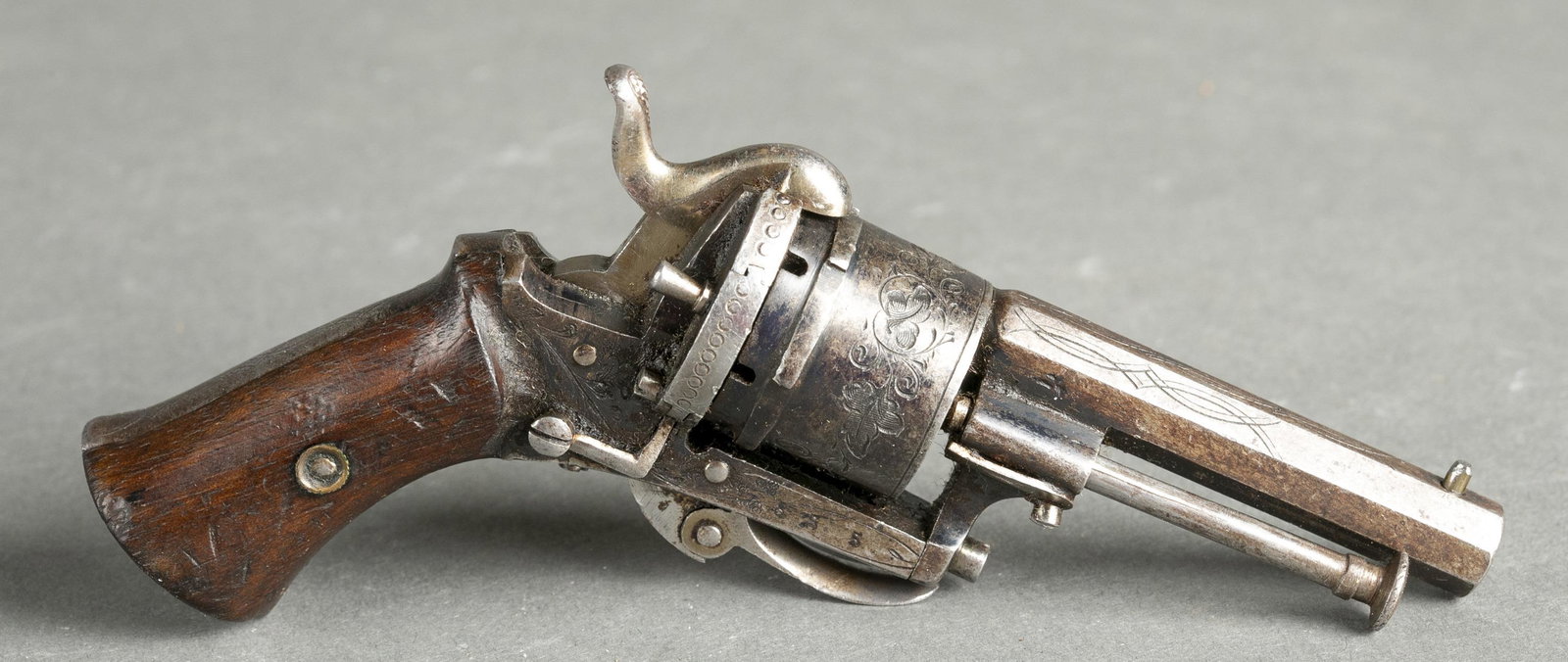 Belgian pinfire revolver, .22 cal.: [Antique Firearm] A Belgian pinfire revolver, .22 cal. Nickel finish. Belgian proof marks. Marked "F.D." in a diamond on left side. 2 1/8" barrel.Condition: Fair condition. 10% of original finish. Dar