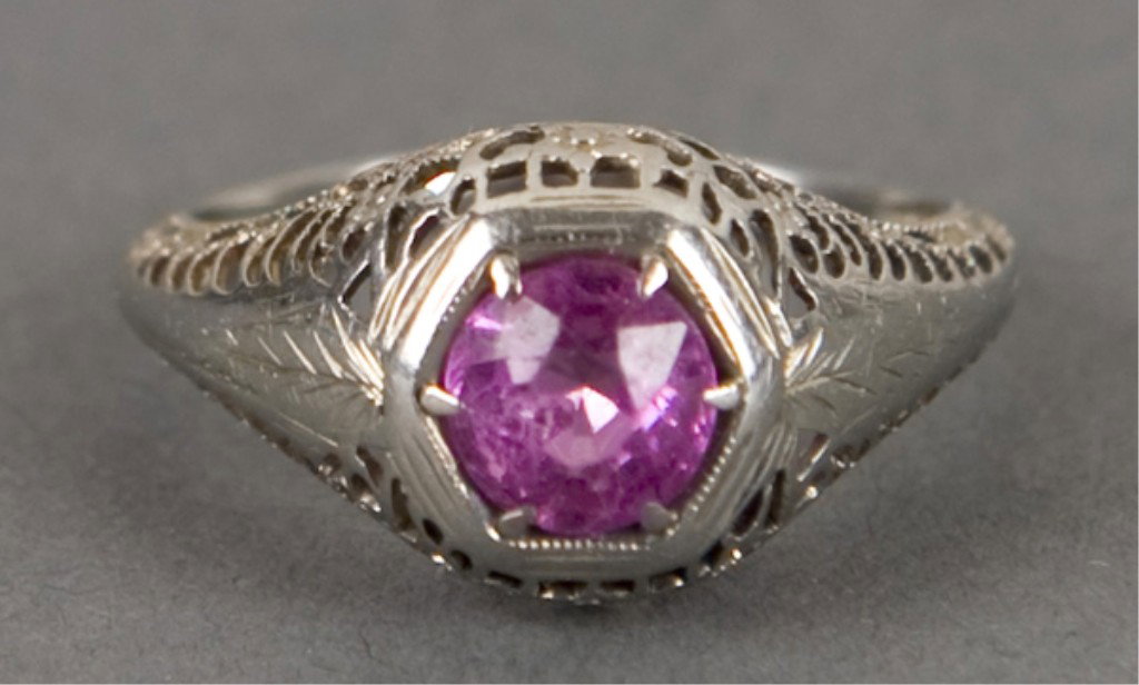 Pink stone solitaire ring.: Solitaire ring in white gold, finely etched with filigree on all sides, stone is deep pink color, may be a tourmaline or glass. Size 5 1/2
