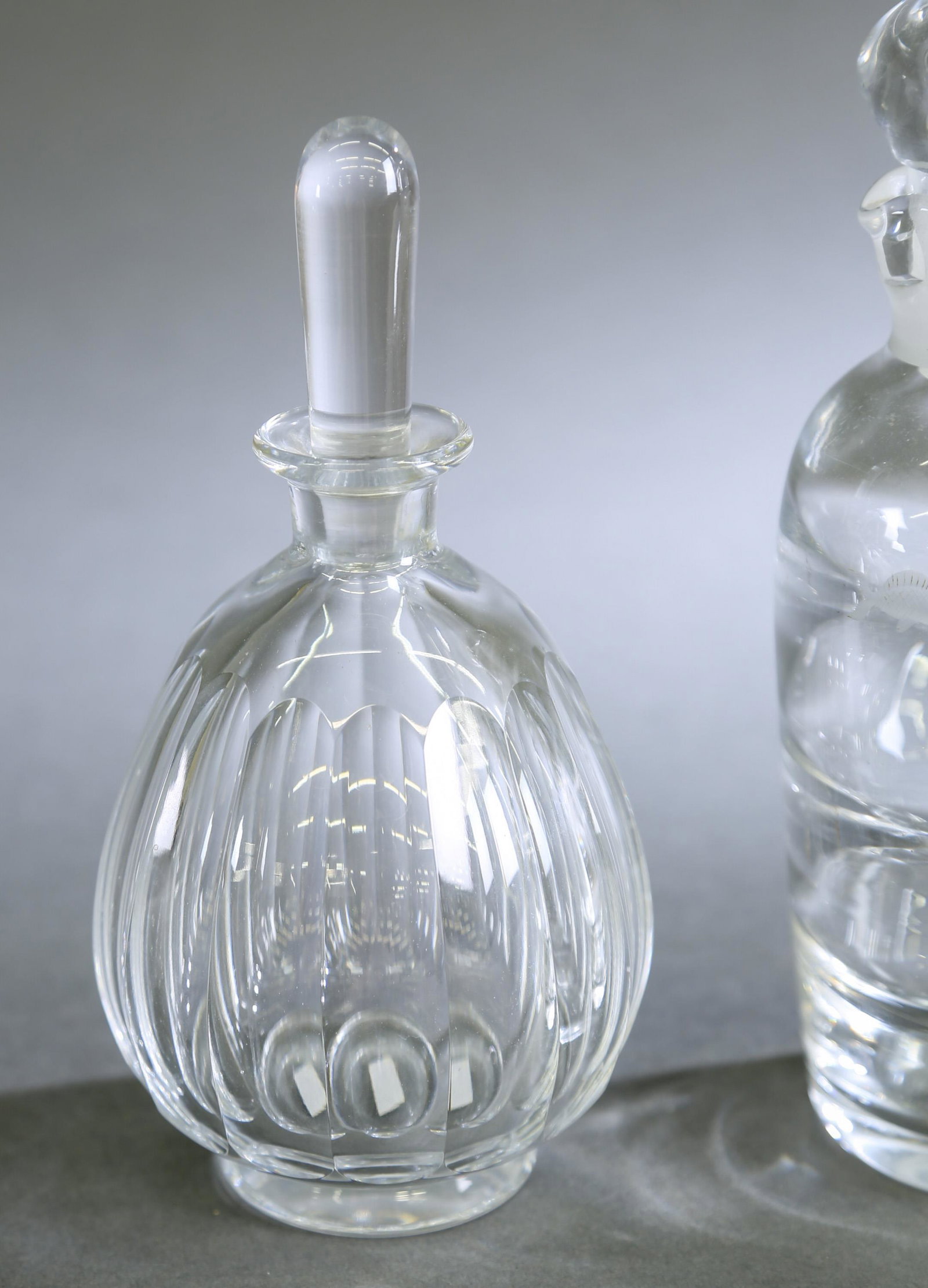 3 Glass decanters.: A group of three glass decanters with stoppers. ++ Kosta decanter. Marked on bottom. 8 3/4" x 3 1/2". ++ Orrefors decanter. Marked on bottom. 8" x 3 1/2". ++ Goran Warff for Kosta decanter. Marked on