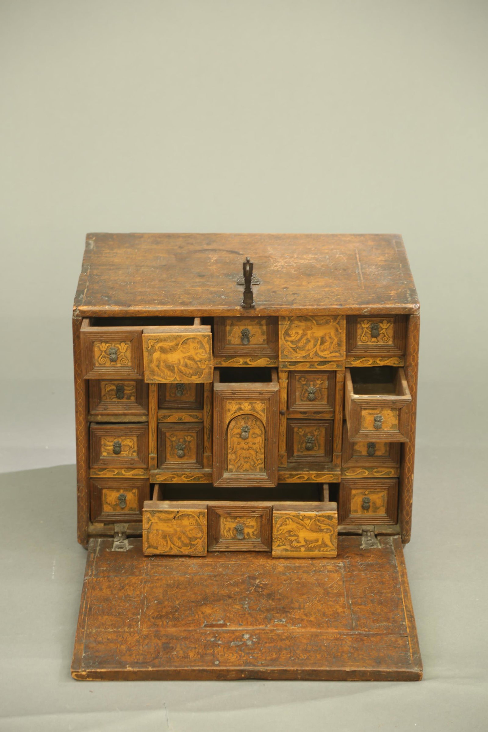 Spanish Colonial cabinet, c. 17th century.: A Spanish Colonial walnut marquetry inlaid traveling chest. Circa 17th century. Finely scroll inlaid across exterior and interior of door. Wrought iron lock with key and pierced round iron estrucheon.