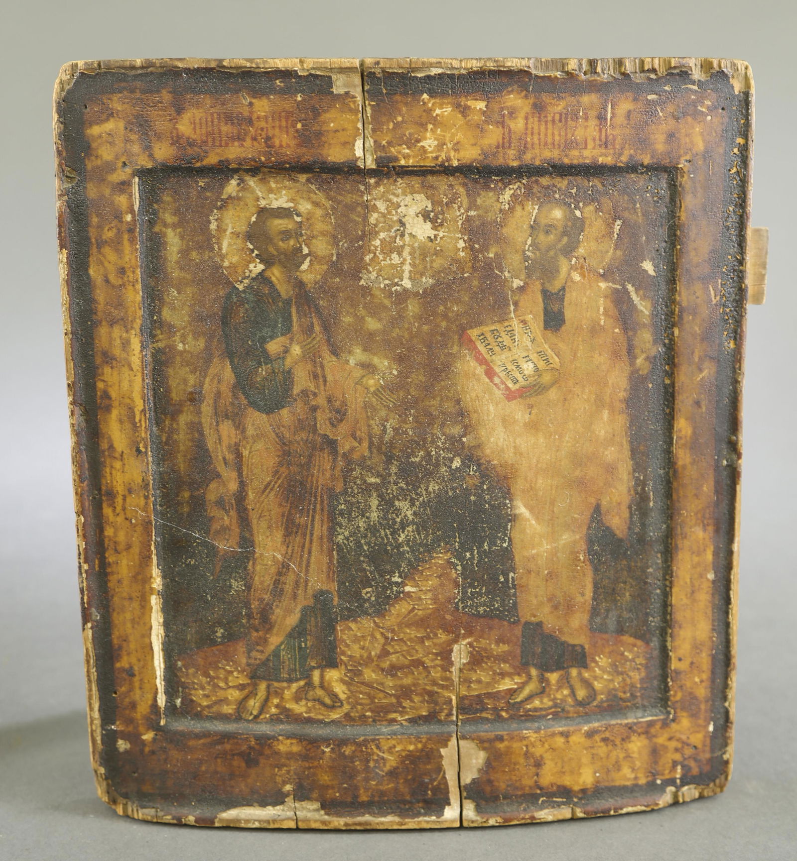 2 Russian icons of Saints, 19th c.: A group of two Russian icons of Saints. Tempera on panel. 19th century. ++ Russian icon of Saint Nicholas holding the gospel, with Jesus Christ to his left side and Virgin Mary on his right. 12 3/4" x
