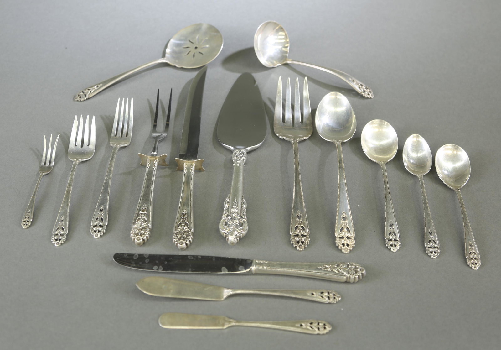 International "Queens Lace" sterling flatware.: An International "Queens Lace" pattern sterling silver flatware for twelve. Eighty-eight pieces. 89.9 ozt. Includes twelve 9 1/8" hollow knives, twelve 7 1/8" dinner forks, twelve 6 1/2" salad forks, 