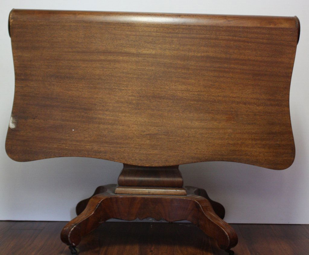 Federal style lift top table on casters, 19th c.: Federal style carved wood lift top table. 19th century. With turned central support. On four legs with casters. 29 1/2"h x 3'w x 34 1/2"d.