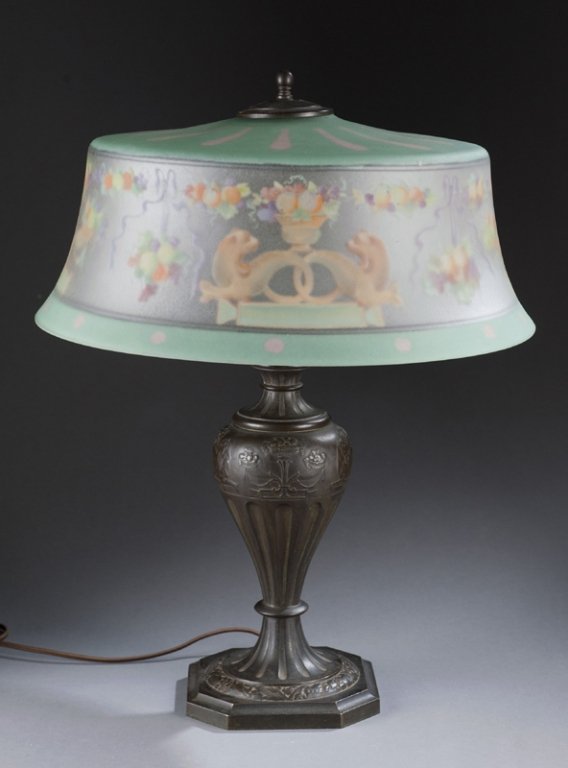 Pairpoint Lamp, late 19th century.: Pairpoint American brass lamp base with painted glass stem. Late 19th century. Reverse painting of cornucopia, floral, lions, and fruits decoration on glass shade. 21 1/2"h. Condition: Chip on glass s