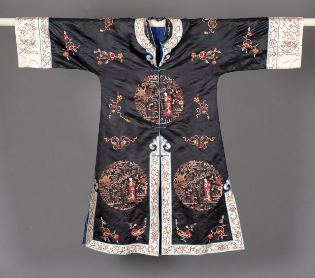 Early 20th C. Chinese Silk Black Robe: Chinese Silk and forbidden stitch embroidery 20th century. With embroidered scenes of young women with foliate Buddhist symbols on black ground. 43" l. x 50" w. Condition: Significant tears and staini