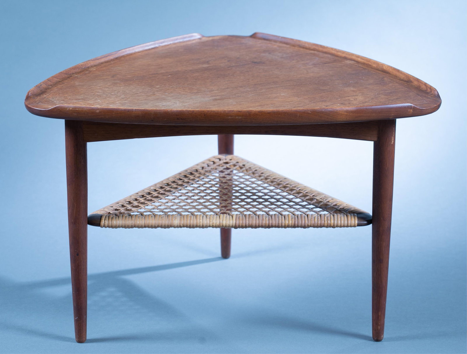 Danish Modern Poul Jensen triangular side table.: A Danish Modern Poul Jensen for Selig triangular "guitar pick" walnut side table, Circa 1960s. Selig label on underside. Woven stretcher. 17" x 25 1/2"