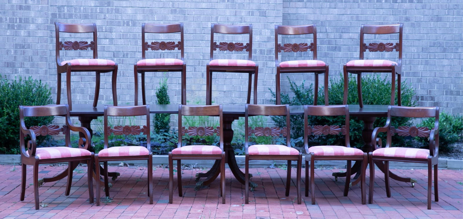 Mahogany banquet table and chairs.: A mahogany banquet table with pedestal base and twelve chairs, 20th century. 10 side chairs and two arm chairs. Table section 30" x 48" x 36" Chairs: 30" x 18 3/4" x 19" with 17 3/4" seat.
