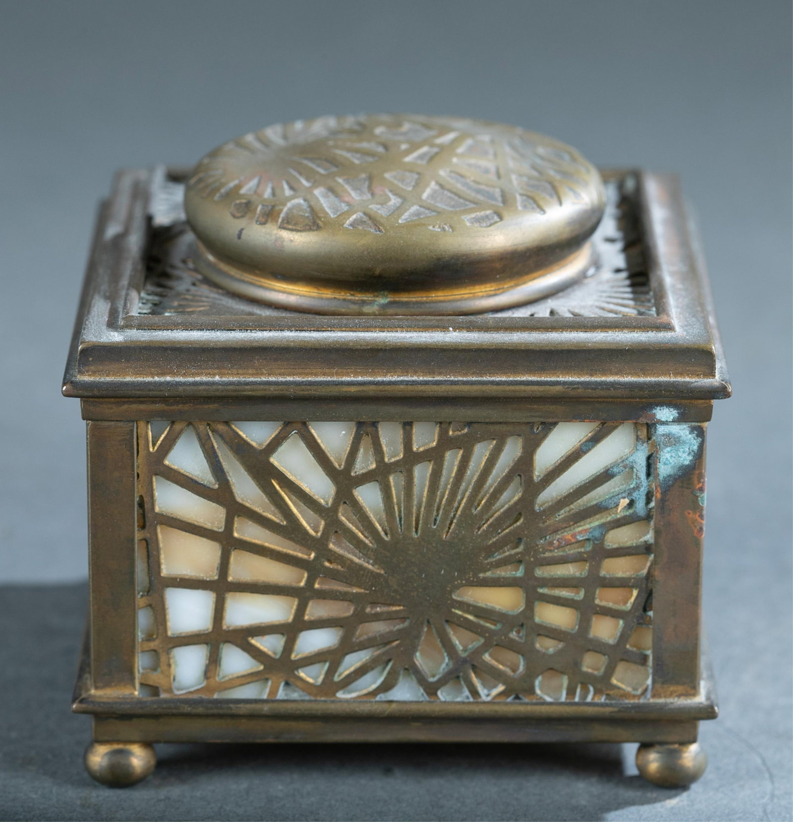Tiffany Studios gilt bronze #845 ink well.: A Tiffany Studios gilt bronze No. 845 ink well, circa 1900. Pine needle design over glass with insert. 3 1/4' x 3 1/4" x 3".