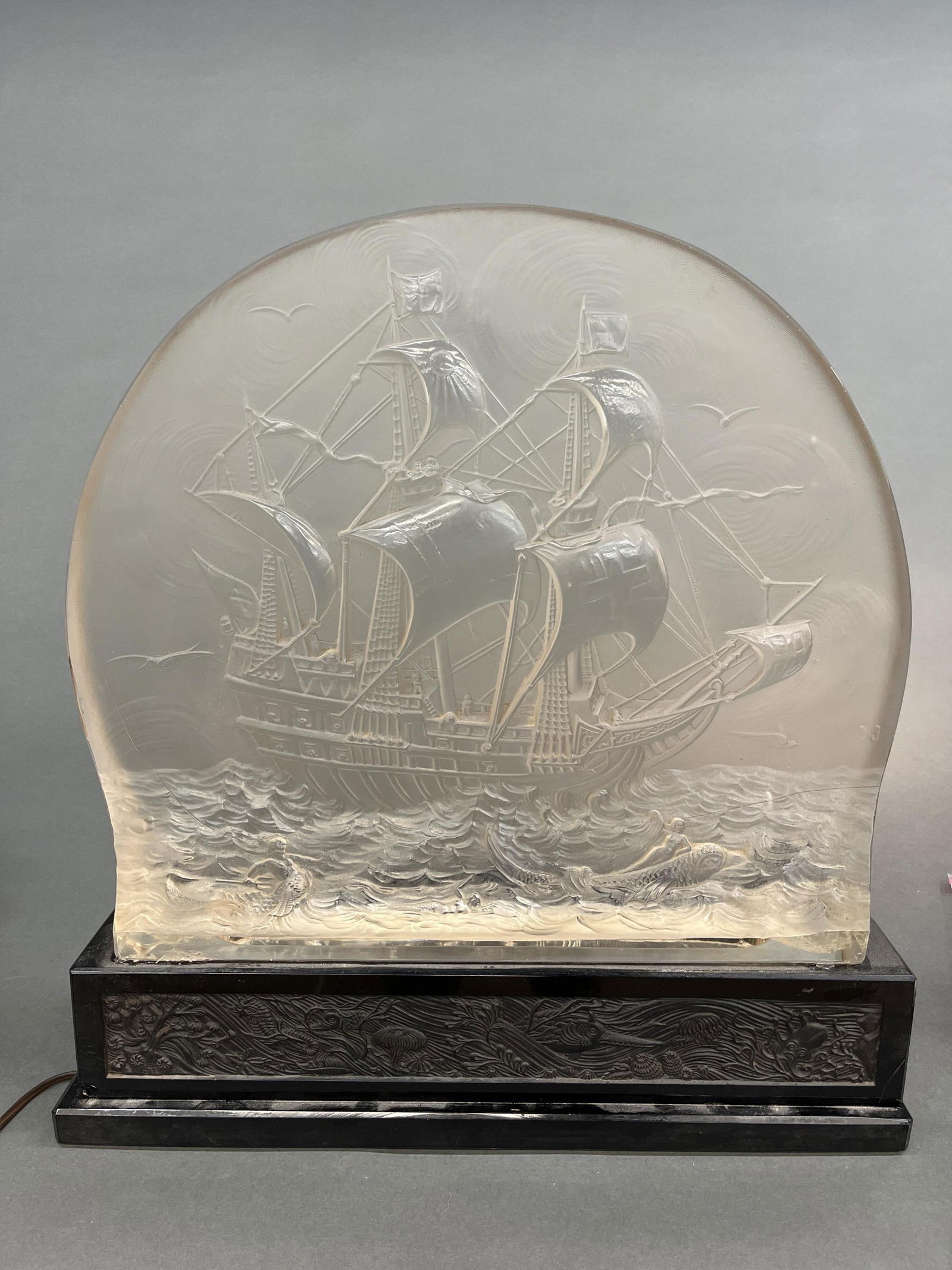 Hoffman, Pate de verre seascape, 1930s.: Heinrich Hoffman (German, 1859-1933). A glass pate de verre of a seascape with a ship on the waves and mermaids lounging on large fish in the foreground. 1930-1936. Marked with Hoffman butterfly. Not