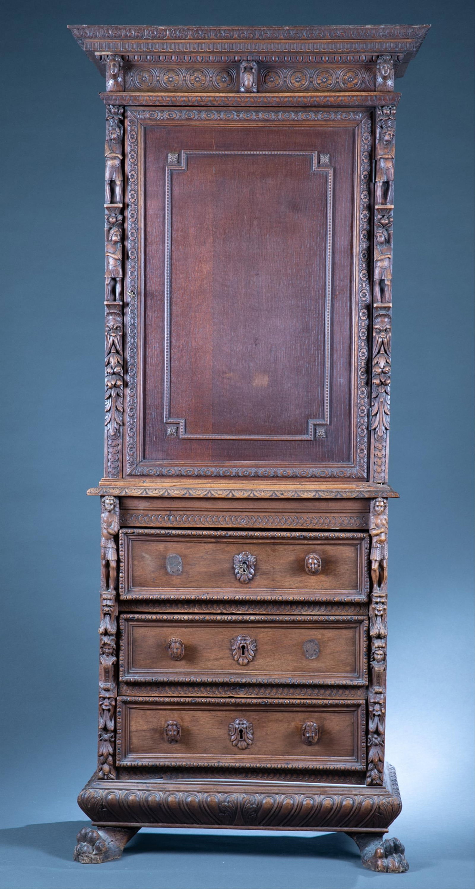 French Renaissance Revival cabinet.: A French Renaissance Revival oak cabinet, 19th century. Carved crown molding with central cartouche flanked by two human face masks. Upper cabinet with side door flanked by floral molding and bas reli