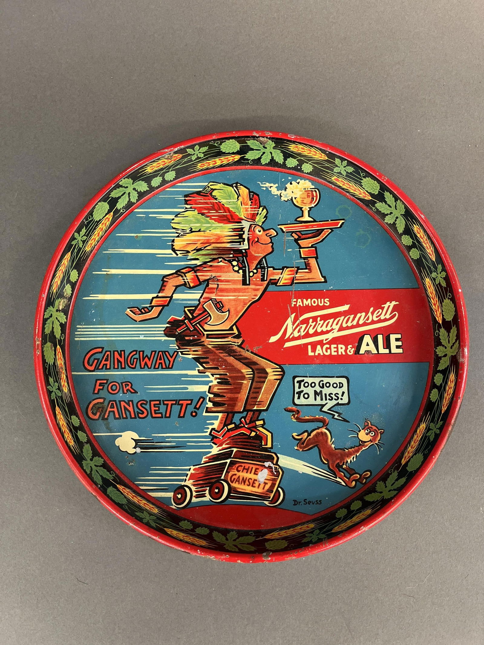 Narragansett Dr. Seuss Chief Gansett tray.: A Narragansett Brewing Company serving tray featuring Chief Gansett holding a tray with a goblet. Designed by Dr. Seuss. Circa 1940s. 12" x 12".Condition: Abrasions, residue.