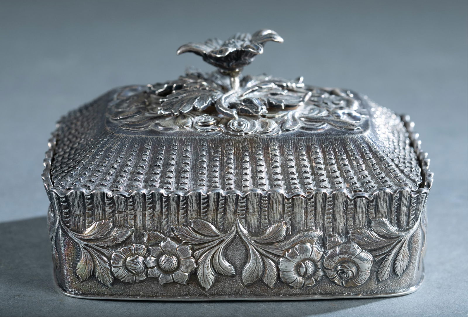 Irish sterling trinket box.: A Robert W Smith, Dublin sterling silver lidded trinket box. Flower finial with repousse flowers along side. Hallmarks and 1830 date mark on bottom. 14.95 ozt. 3" x 5" x 3 1/4"