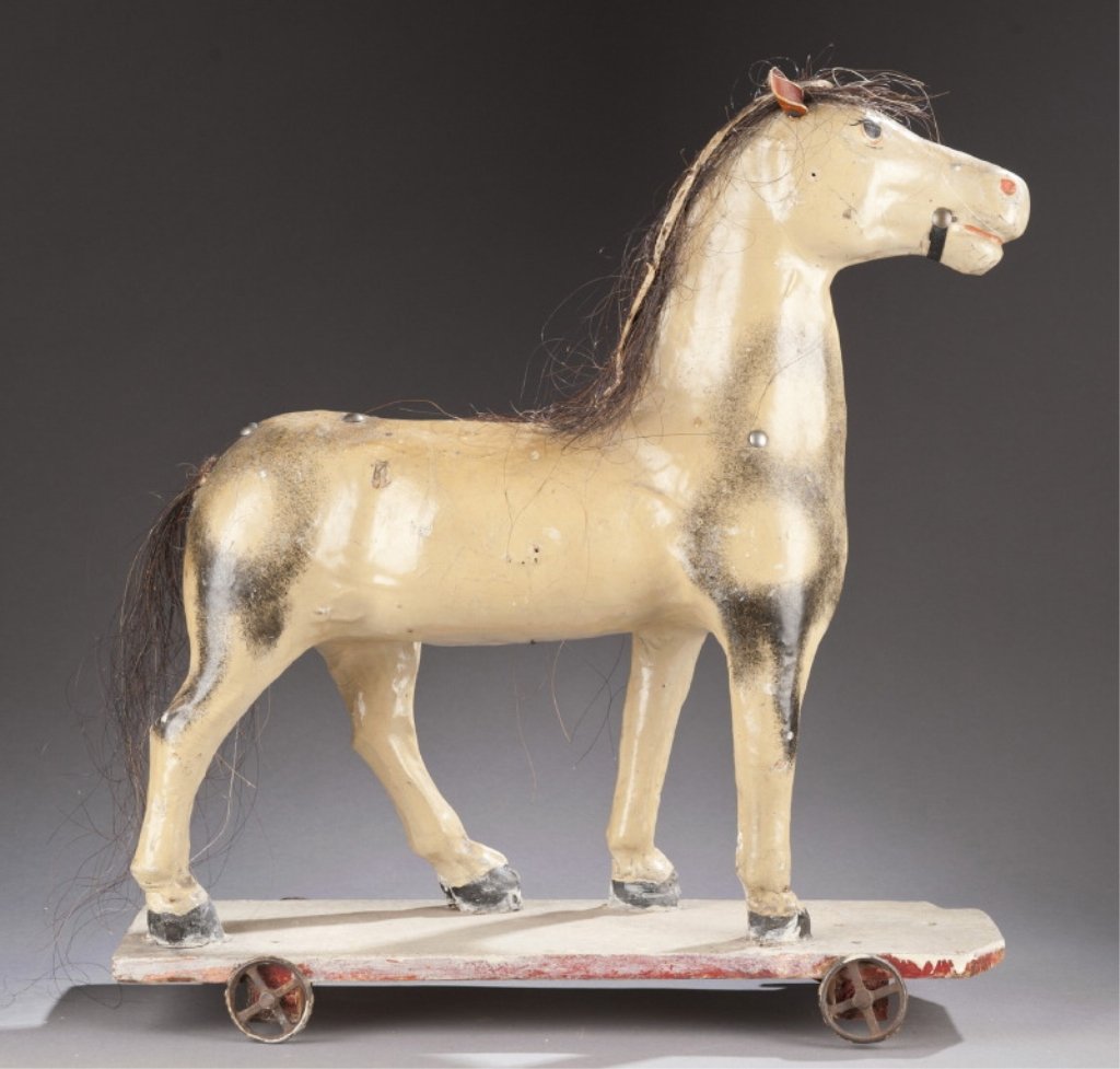 German papier mache horse pull toy.: German papier mache horse pull toy. c. 1920-1930s. Horse on wooden base with metal wheels. Marked on bottom "Deutsches Reichpatent". 14" long.
