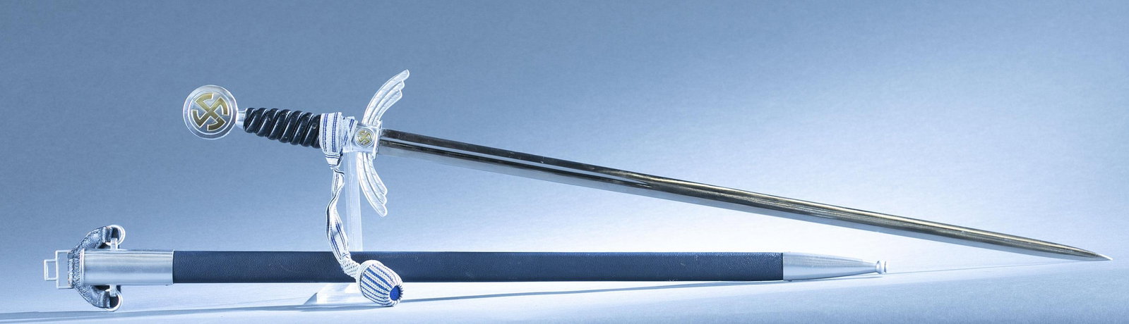 WWII German Luftwaffe Officers sword with scabbard: A WWII German Luftwaffe Officers sword with scabbard and knot by WKC Solingen. 26 1/4" double edged blade. Ricasso marked W.K.C. Solingen. Nickel silver crossguard and pommel with corded leather grip.