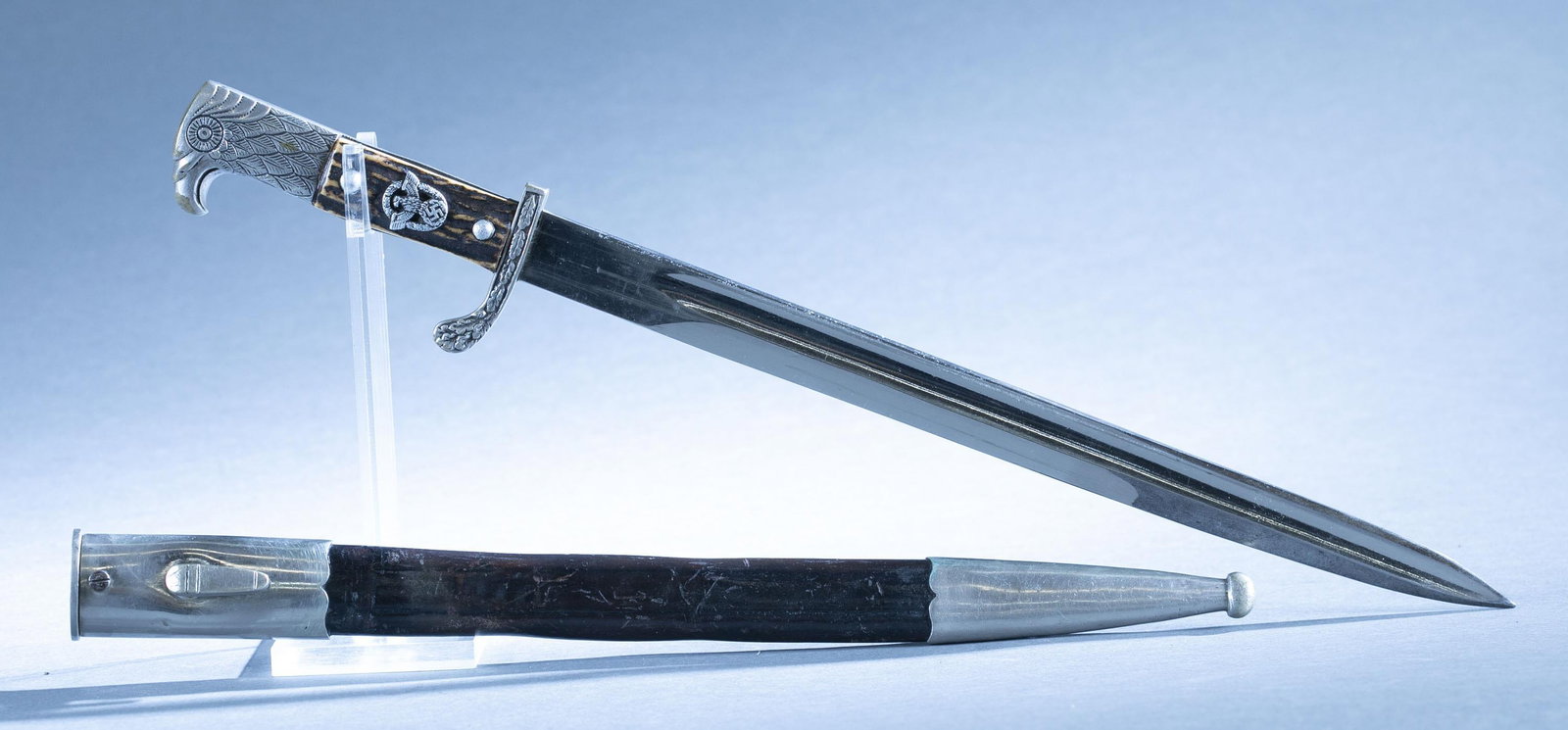 WWII German Police bayonet with scabbard: A WWII German Police bayonet with scabbard by Carl Eickhorn, Solingen. 13" blade. Ricasso maker marked. Nickel oak leaf quillion and eagle head pommel. Stag grips. Leather and nickel mounted scabbard.