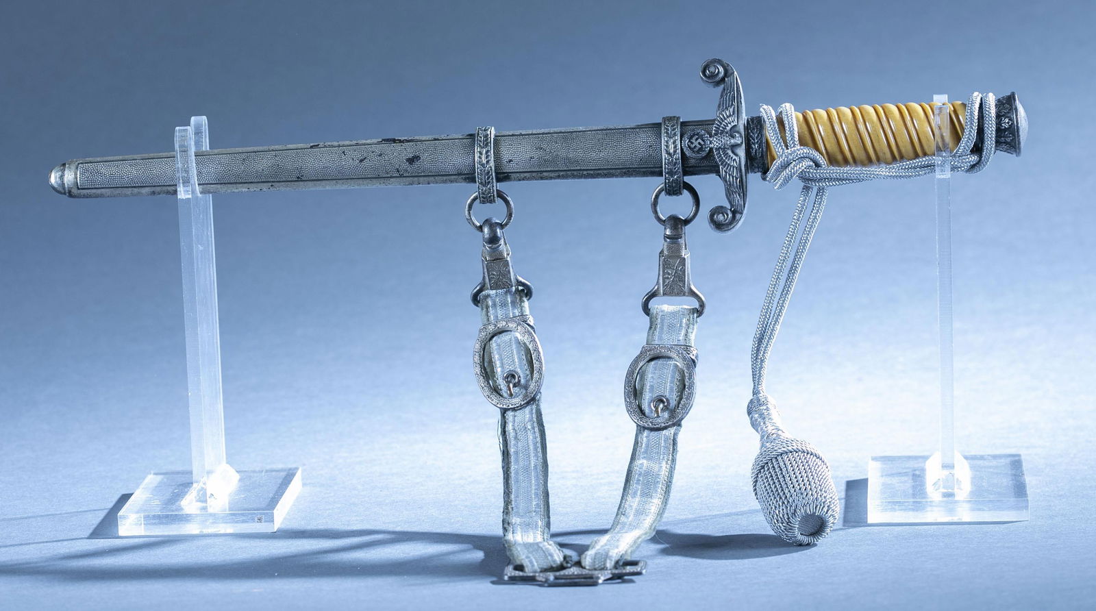 WWII German Army Officer's Dagger with scabbard: A WWII German Army Officer's Dagger with scabbard, hanger, and knot. 10" double edged blade. Ricasso maker marked. Nickel plated crossguard and pommel. Yellow bakelite grips. Nickel plated scabbard. D