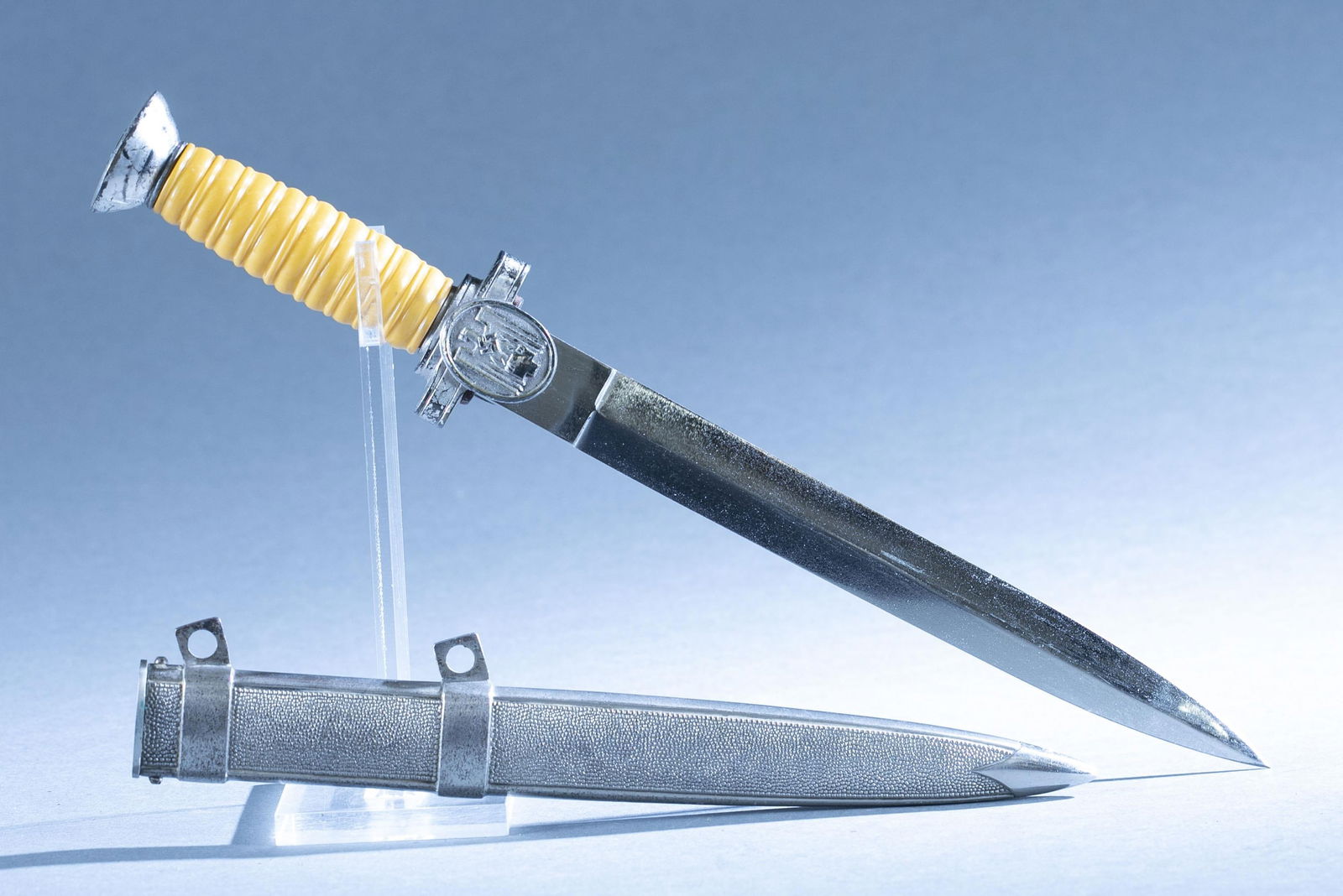 WWII German DRK Red Cross Leader dagger: A WWII German Deutschen Rotes Kreuz Red Cross dagger with scabbard. 9 1/2" double edge blade. Unmarked ricasso. Nickel silver crossguard and pommel. Bakelite grip. Nickel silver scabbard. 14 1/2" over