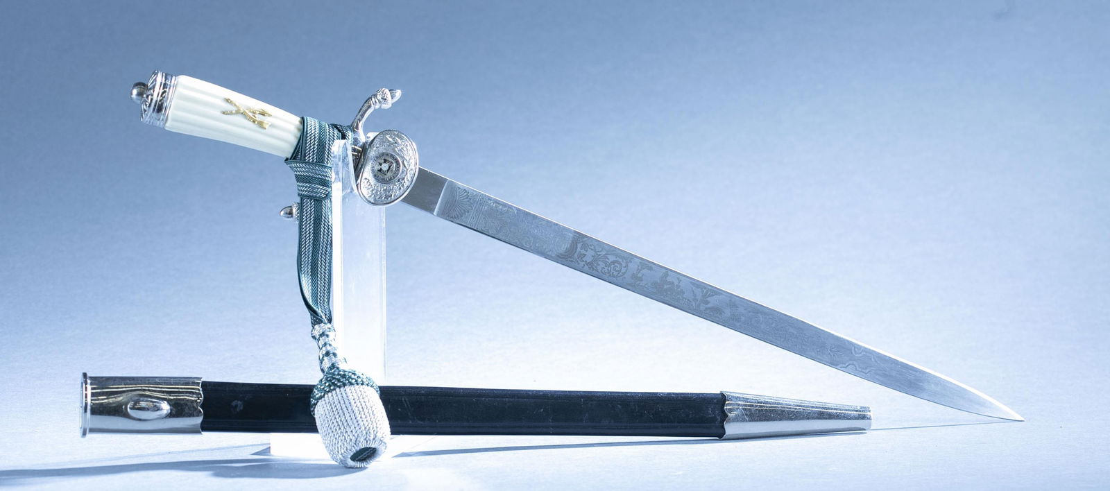 WWII German DSV hirschf?nger dagger with scabbard: A WWII German Deutscher Schutzen Verband hirschfanger hunting dagger with scabbard and knot by E. F. Horster, Solingen. 15 1/2" blade with acid etched hunting scene. Ricasso maker marked. Nickel cross