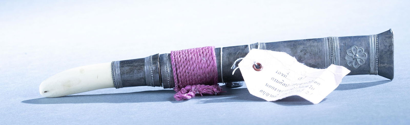Thai Shan Tribe Dha Hmyaung knife: A Shan Tribe Northern Hill Tribe Thailand Dha Hmyaung knife, 19th Century. 5 3/4" single edged blade. Silver and tooth grip. Silver scabbard with filigree rosette. 10 3/4" overall. Provenance: A Fine