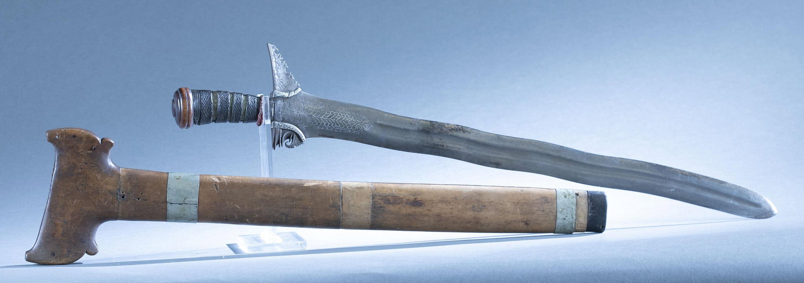 Filipino Moro kris sword with scabbard: A Filipino Moro, Mindanao, or Sulu Archipelago kris sword with scabbard, 19th century. 22 1/2" fully wavy blade with sliver stirrups. Brass and woven hilt and round wood pommel. Wood scabbard with sil