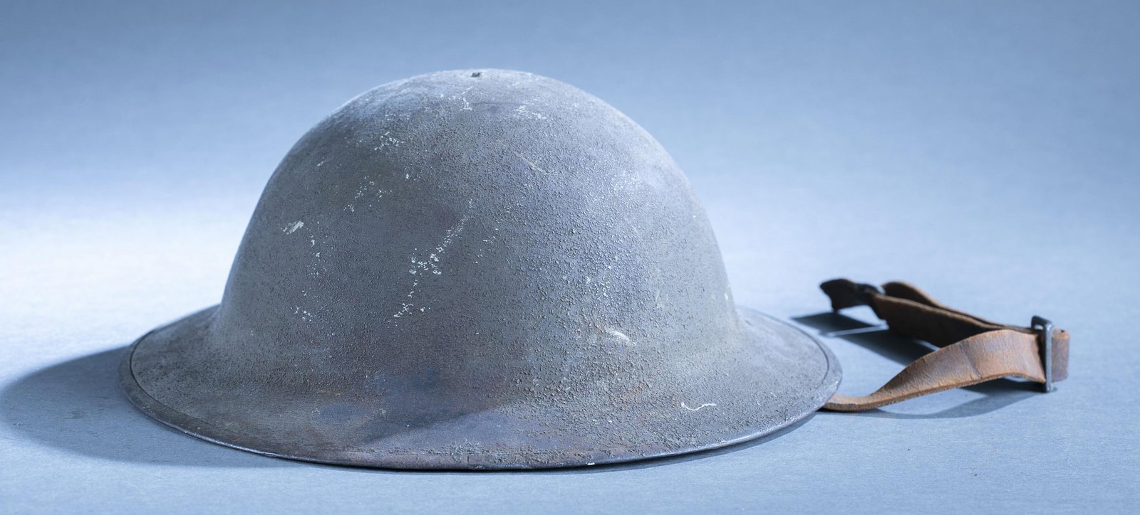 WW1 U.S. M1917 helmet: A WW1 U.S. Model 1917 helmet with original liner. 4 1/2" x 12 3/8" x 11 3/8" Condition: Broken chinstrap.