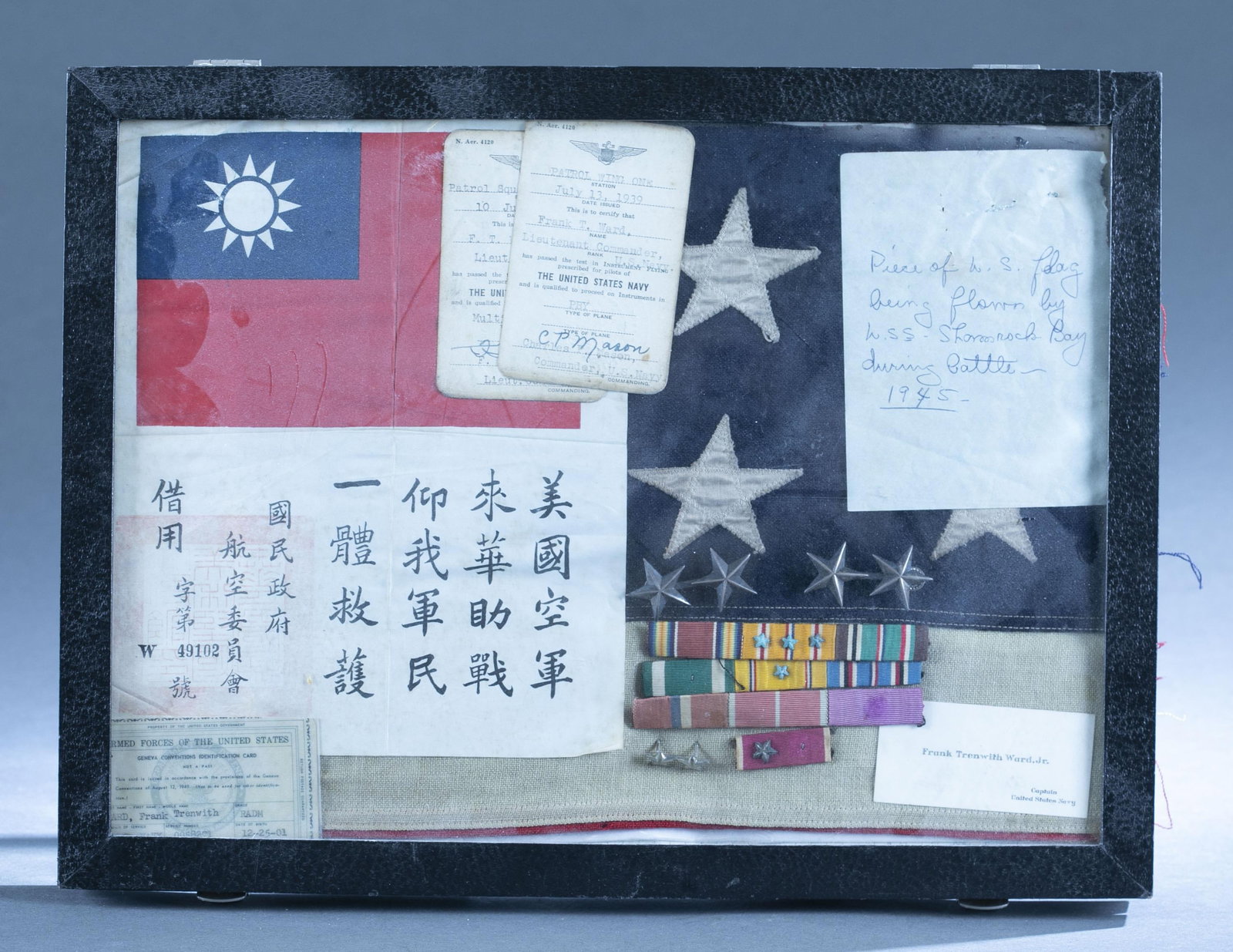 WWII Navy Airman shadowbox: A WWII Navy Airman Lt. Commander Frank T. Ward shadowbox. Includes Flying Tiger silk Rescue Patch or Blood Chit, aviators licenses, insignia, Geneva Conventions ID card, and piece of U.S. flag.12 1/8"