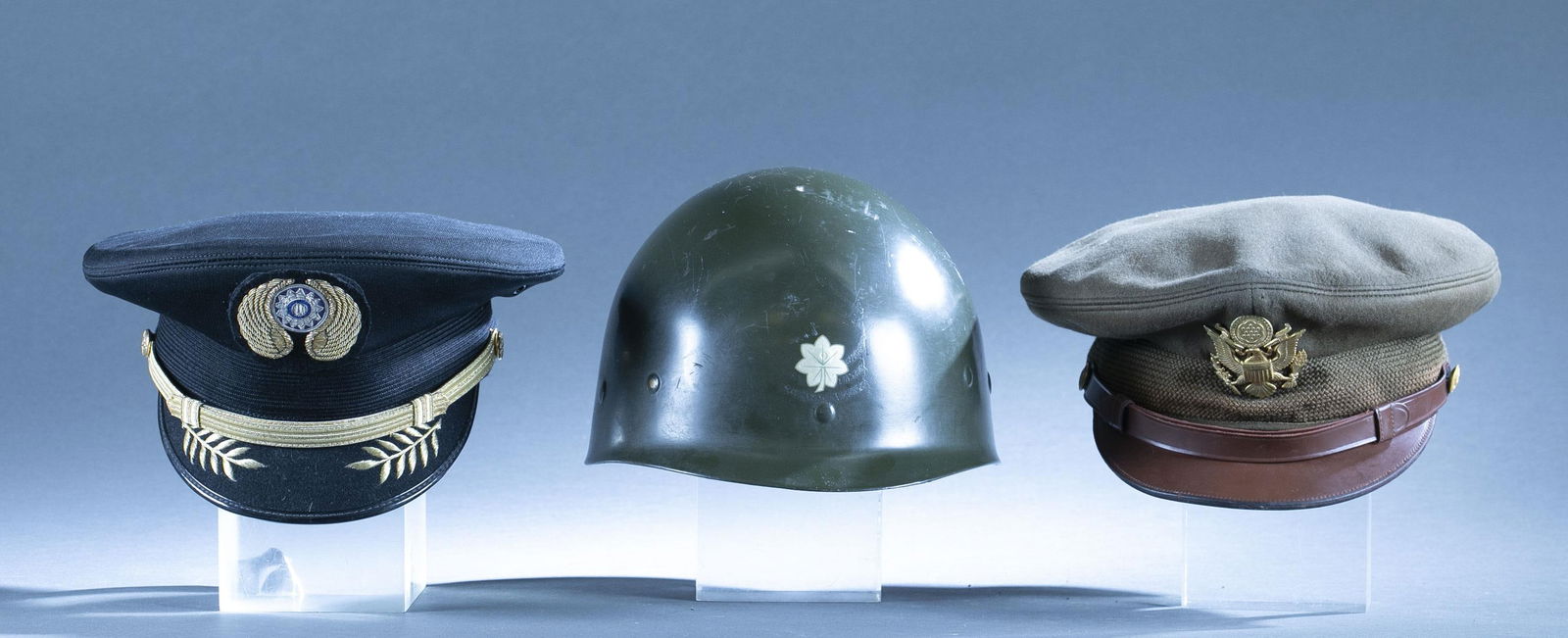 3 U.S. visor caps and helmets: A group of two visor caps and M1 helmet liner. ++ Reproduction The First American Volunteer Group "Flying Tigers" visor cap. ++ WWII/ Korean War U.S. Army Officer visor cap. ++ U.S M1 helmet liner wit