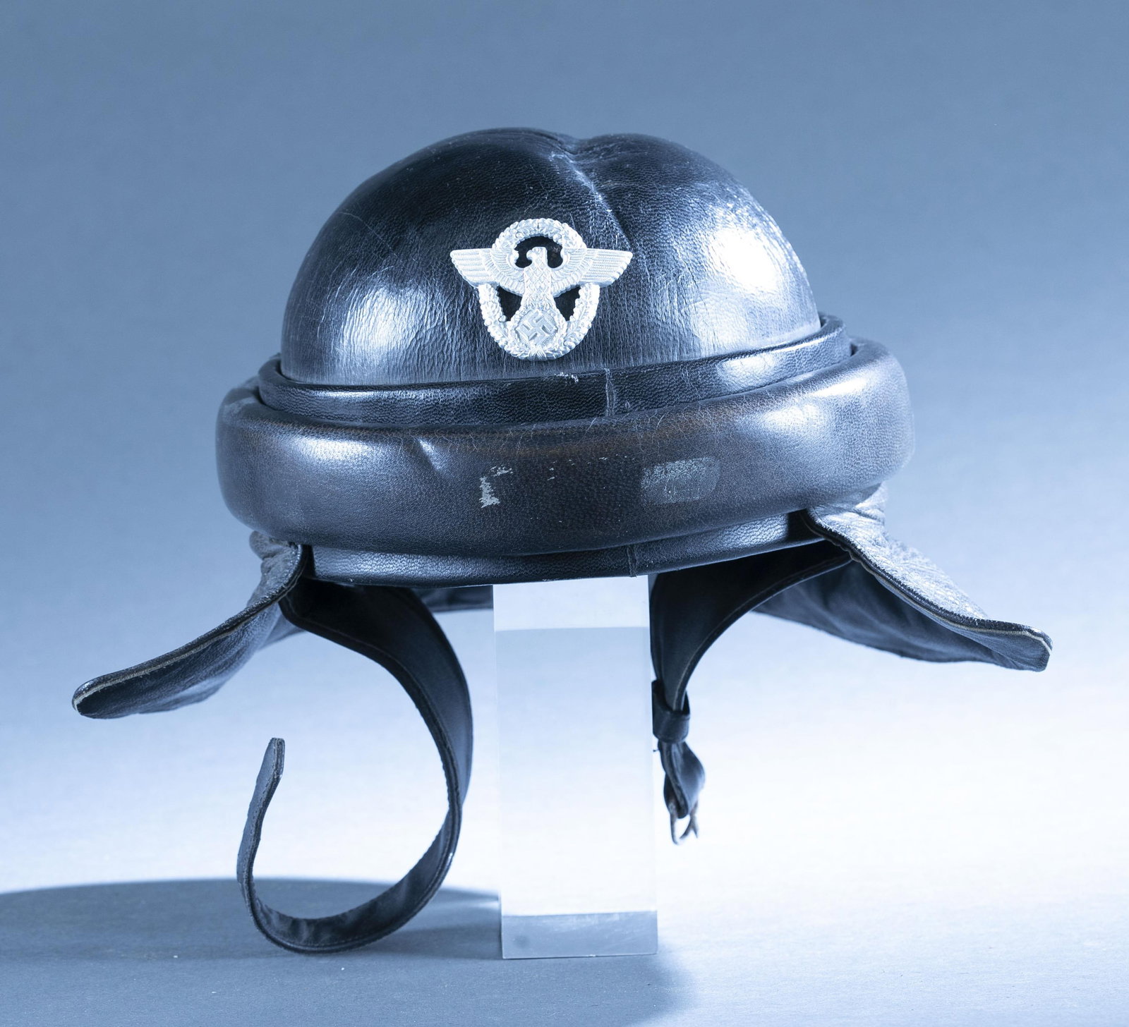 WWII German NSKK motorcycle helmet: A WWII German NSKK motorcycle leather helmet. aluminum badge on front. 6" x 8 1/2" Condition: Dent in top.