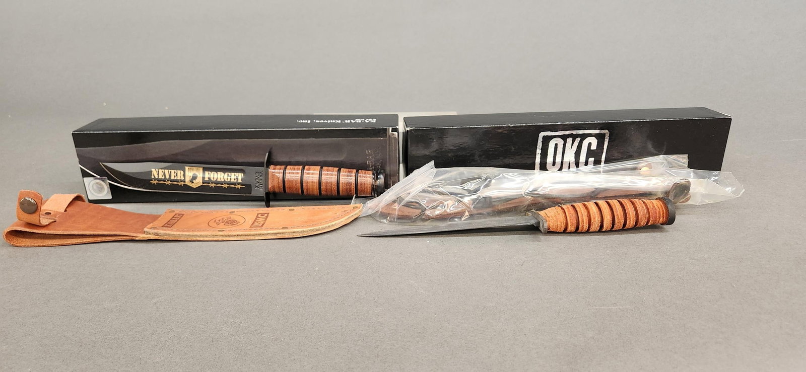 2 Fighting knives MIB: A group of two fighting knives, mint in box. ++ KA-BAR Knives Inc. POW MIA Commemorative U.S.M.C. fighting knife, . 7" overall. 12" overall. Box: 2 3/8" x 13 1/2" x 3 1/4" ++ Ontario Knife Company OKC