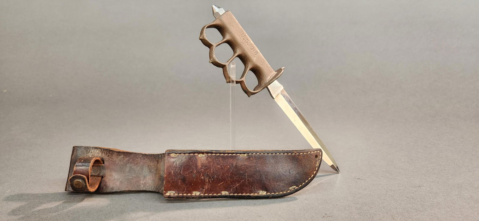 Replica U.S. M1918 trench knife: A replica WW1 U.S. M1918 trench knife. 6 1/2" blade with cast brass body. Includes leather scabbard. 11 1/2" overall.