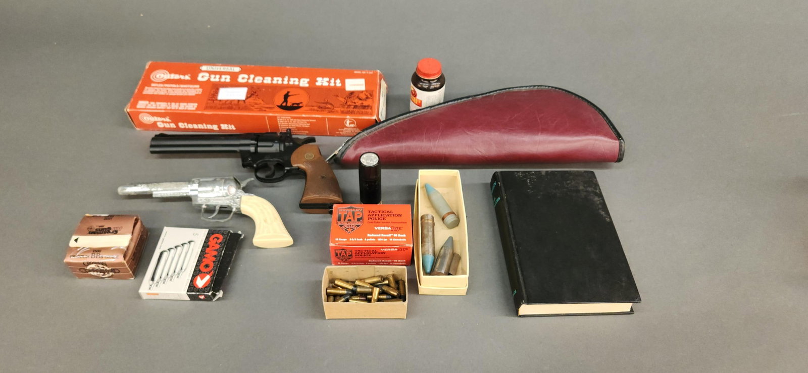 Assorted ammunition and accessories: A group of assorted ammunition and accessories. Including three 20mm training rounds, gun cleaning kit, box of 8 rounds Honardy TAP 12 gauge shells, 29 loose rounds of 32 S&W Long, and Crosman 357 air