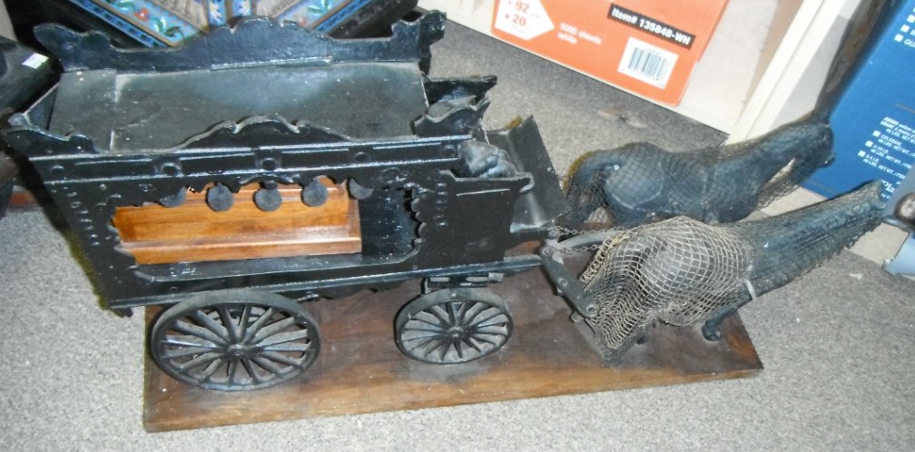Horse-drawn hearse carriage of cast iron.: Horse-drawn hearse carriage of cast iron.Attached to wood base.