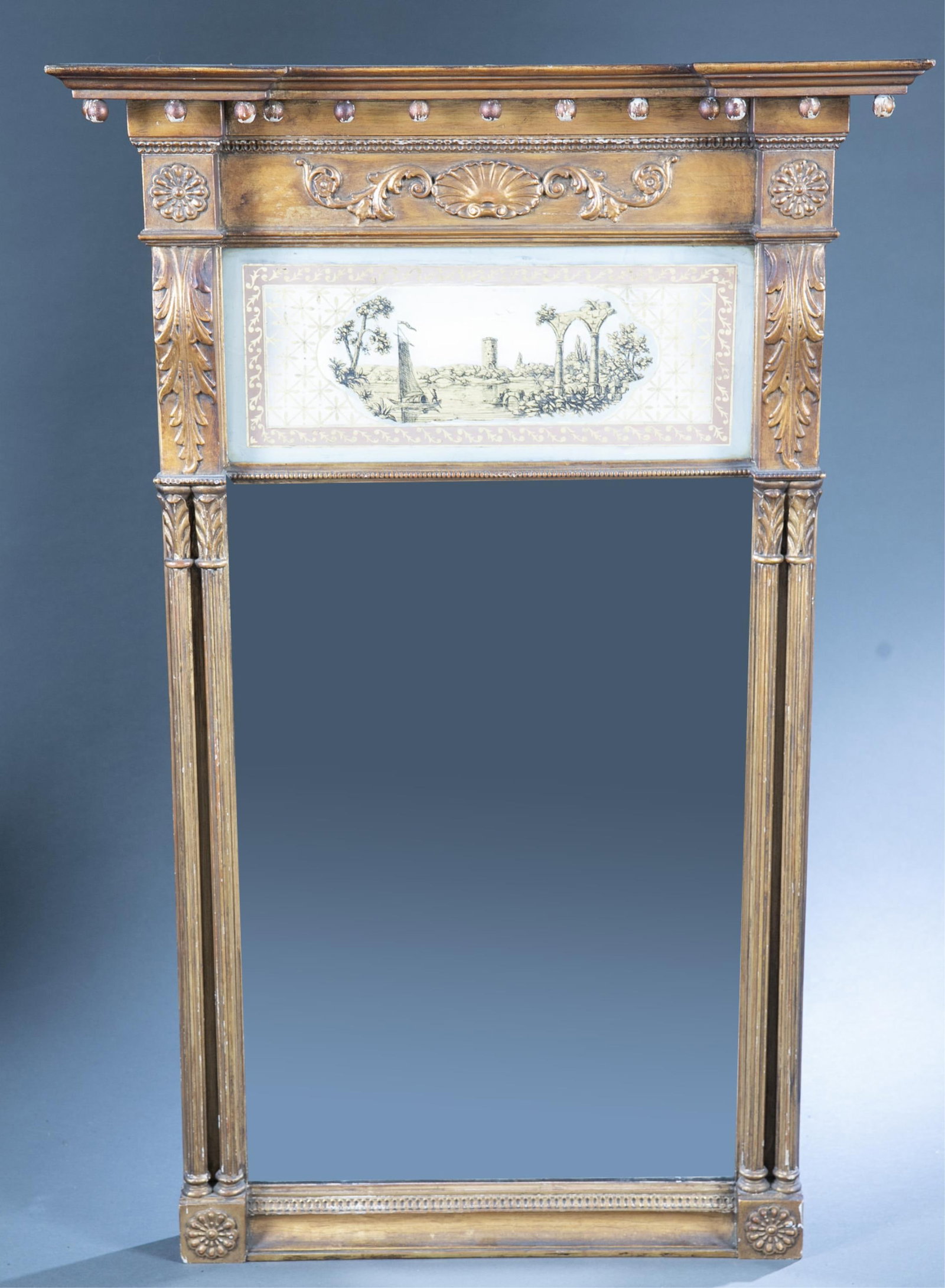 American Empire gilt pier mirror.: An American Empire gilt pier mirror with eglomise panel. Circa 1840's. Frame with fluted columns and foliate details. 44 1/2" x 29" Some chipping to gilt.