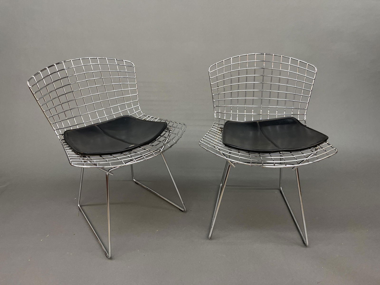 4 Knoll Bertoia side chairs: A group of four Harry Bertoia for Knoll chrome side chairs with black vinyl seats. 28 3/4" x 21 3/4" x 19 3/4". Provenance: Includes receipt.