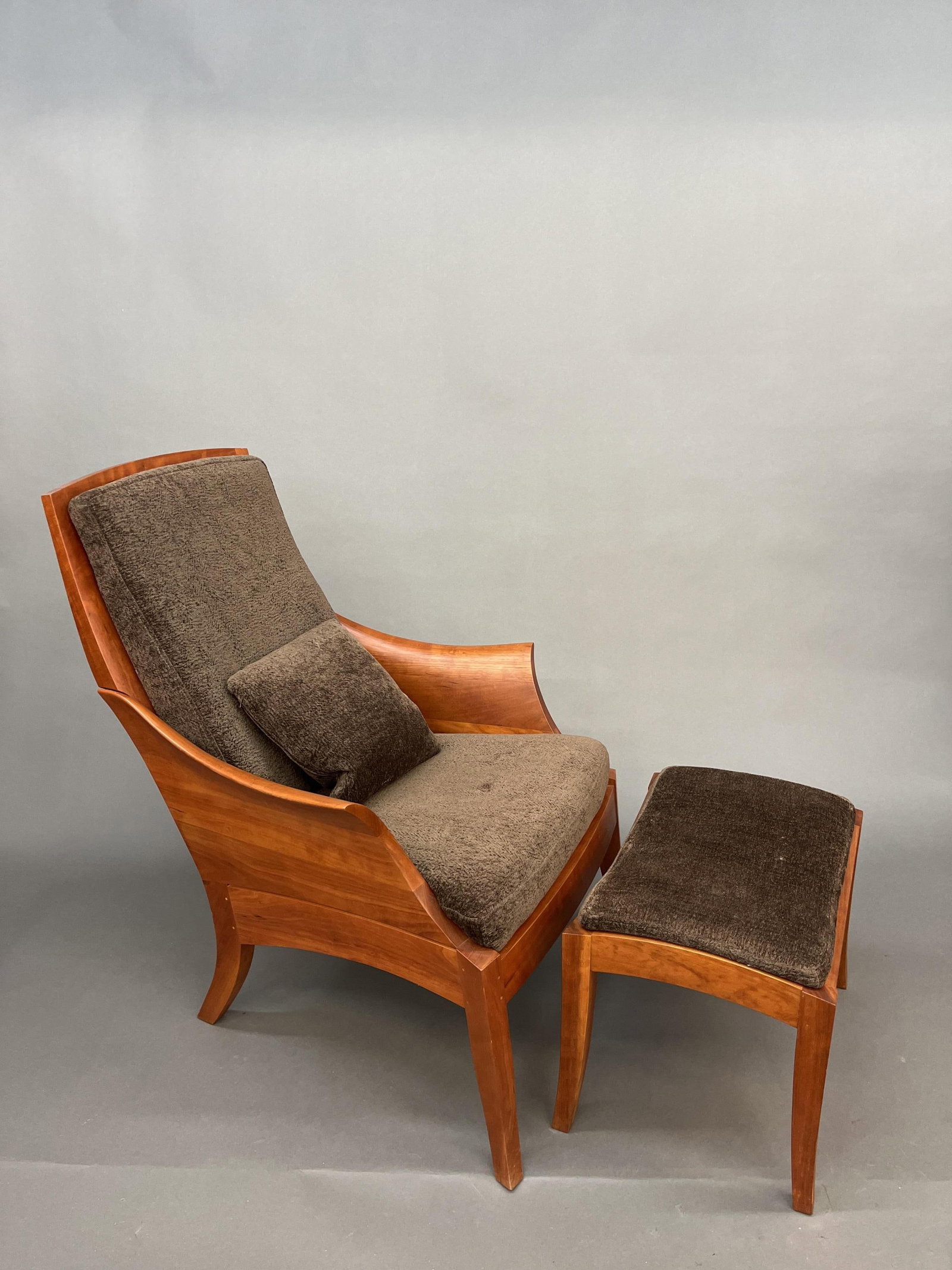 Thos. Moser walnut Wing Chair with ottoman.: A Thos. Moser, Maine walnut sculpted Wing Chair with Wing Ottoman and Knoll Venue Alligator upholstery. Signed and dated 2004 on underside. 39" x 28" x 35" and 17"H x 21"W x 15"L.