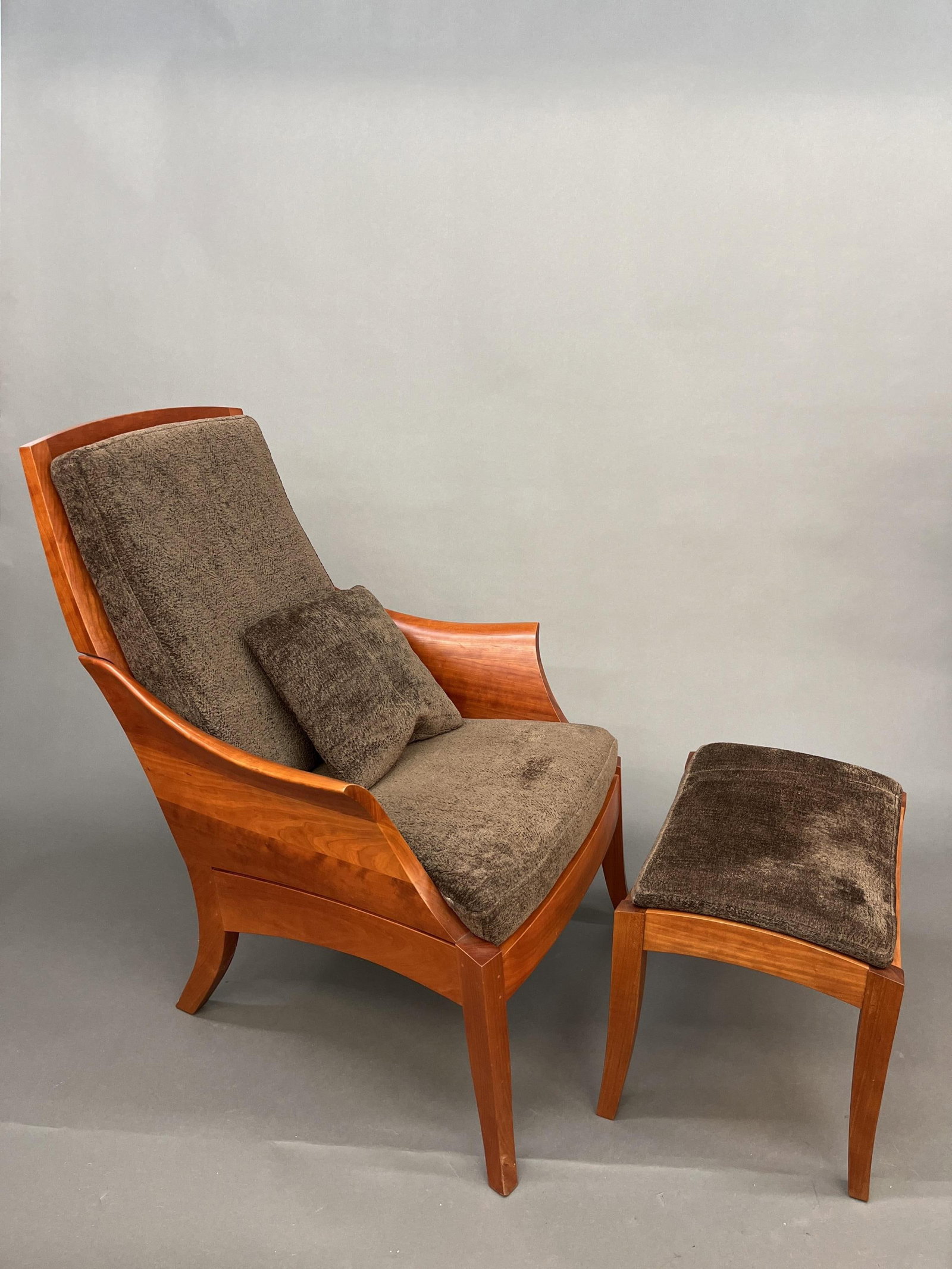 Thos. Moser walnut Wing Chair with ottoman.: A Thos. Moser, Maine walnut sculpted Wing Chair with Wing Ottoman and Knoll Venue Alligator upholstery. Signed and dated 2004 on underside. 39" x 28" x 35" and 17"H x 21"W x 15"L.
