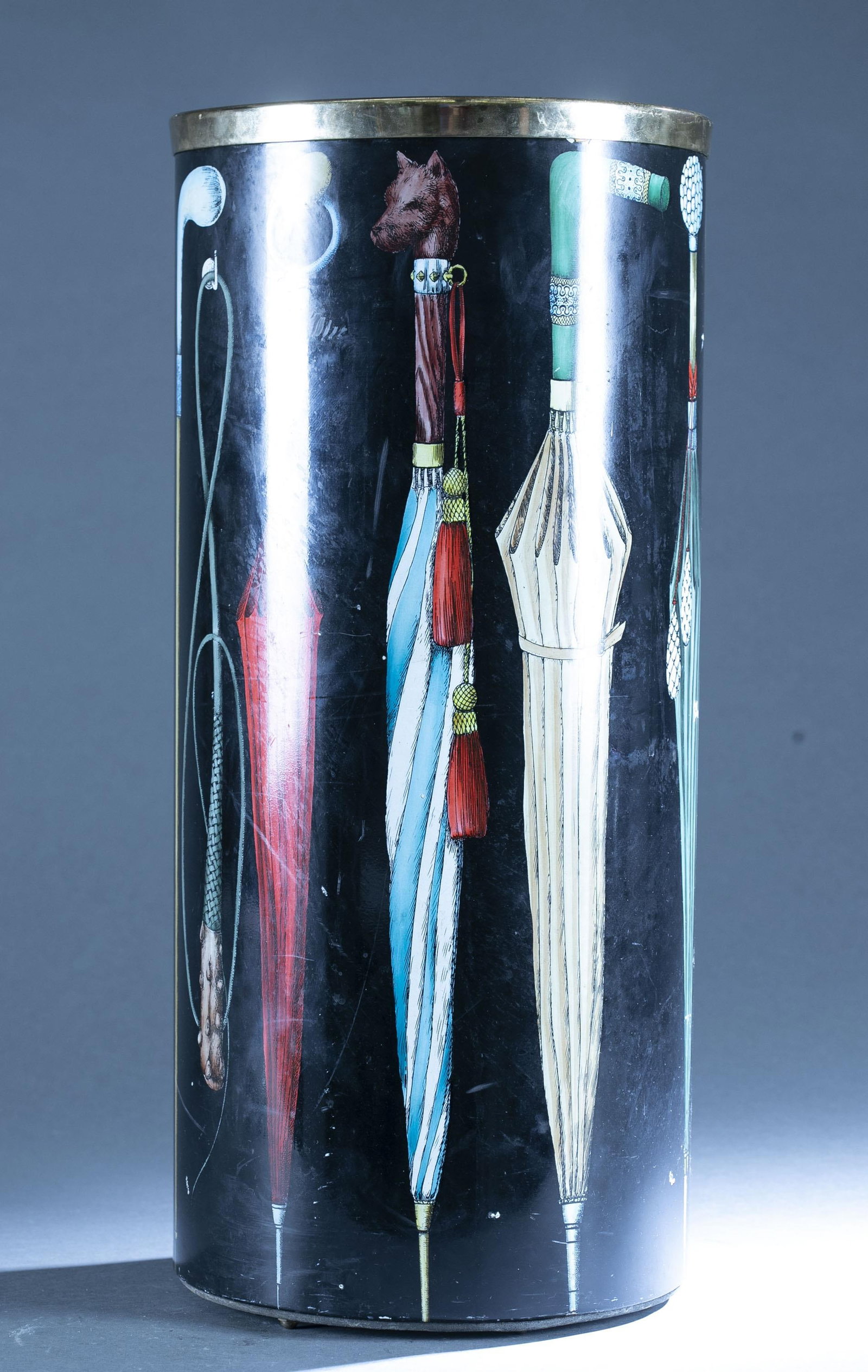 Fornasetti "Ombrelli" umbrella stand.: A Piero Fornasetti "Ombrelli" umbrella stand. Painted umbrellas and canes on black ground.. Label on bottom: Fornasetti Milano Made in Italy. 23" x 10 1/4"scratches and chips throughout