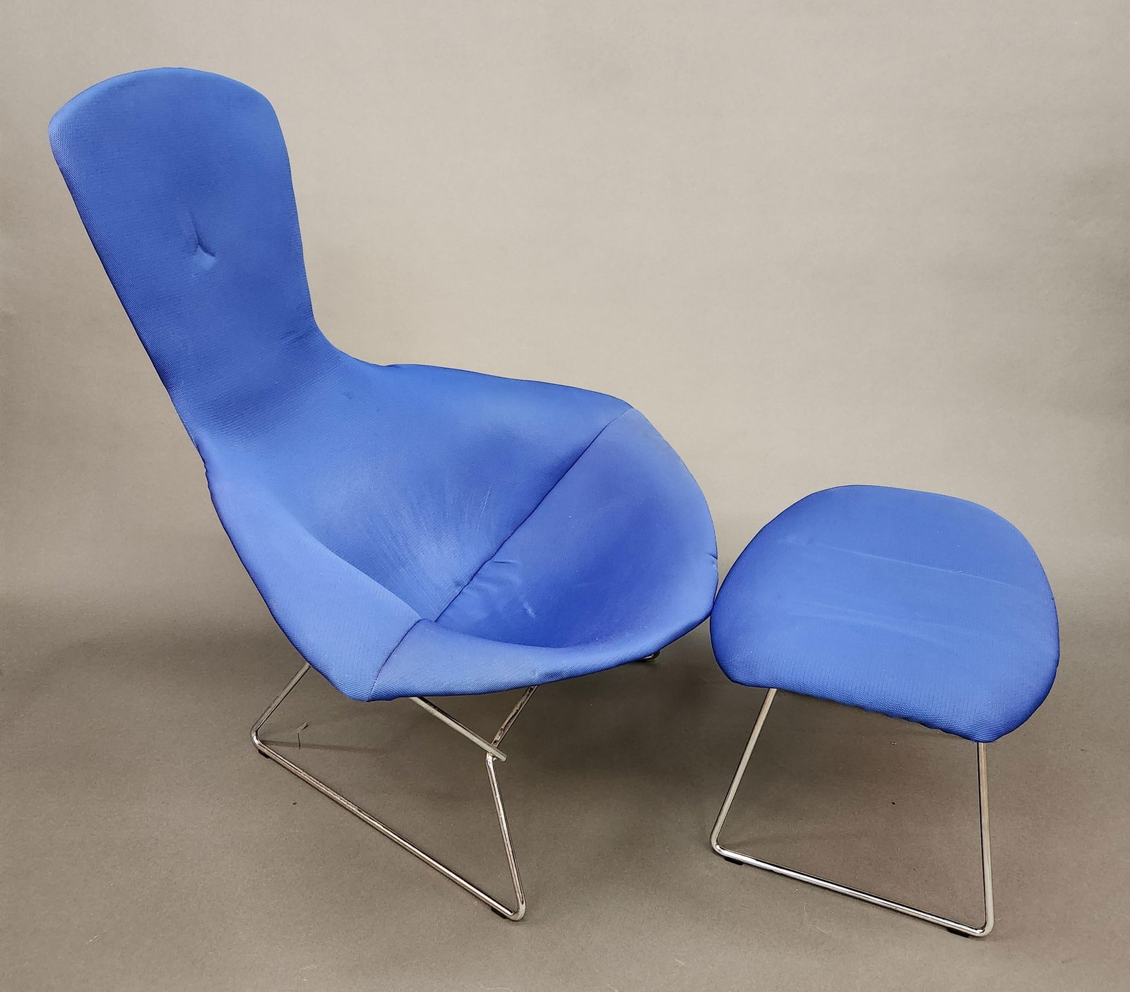 Harry Bertoia 'Bird' chair and ottoman: A Harry Bertoia 'Bird' chair and ottoman for Knoll. Blue fabric over chrome steel wire frame. 38 1/4" x 38" x 35" Ottoman:14 3/4" x 24" x 17"